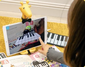 タブレットに映ったピアノのAR映像に指で触れる子ども